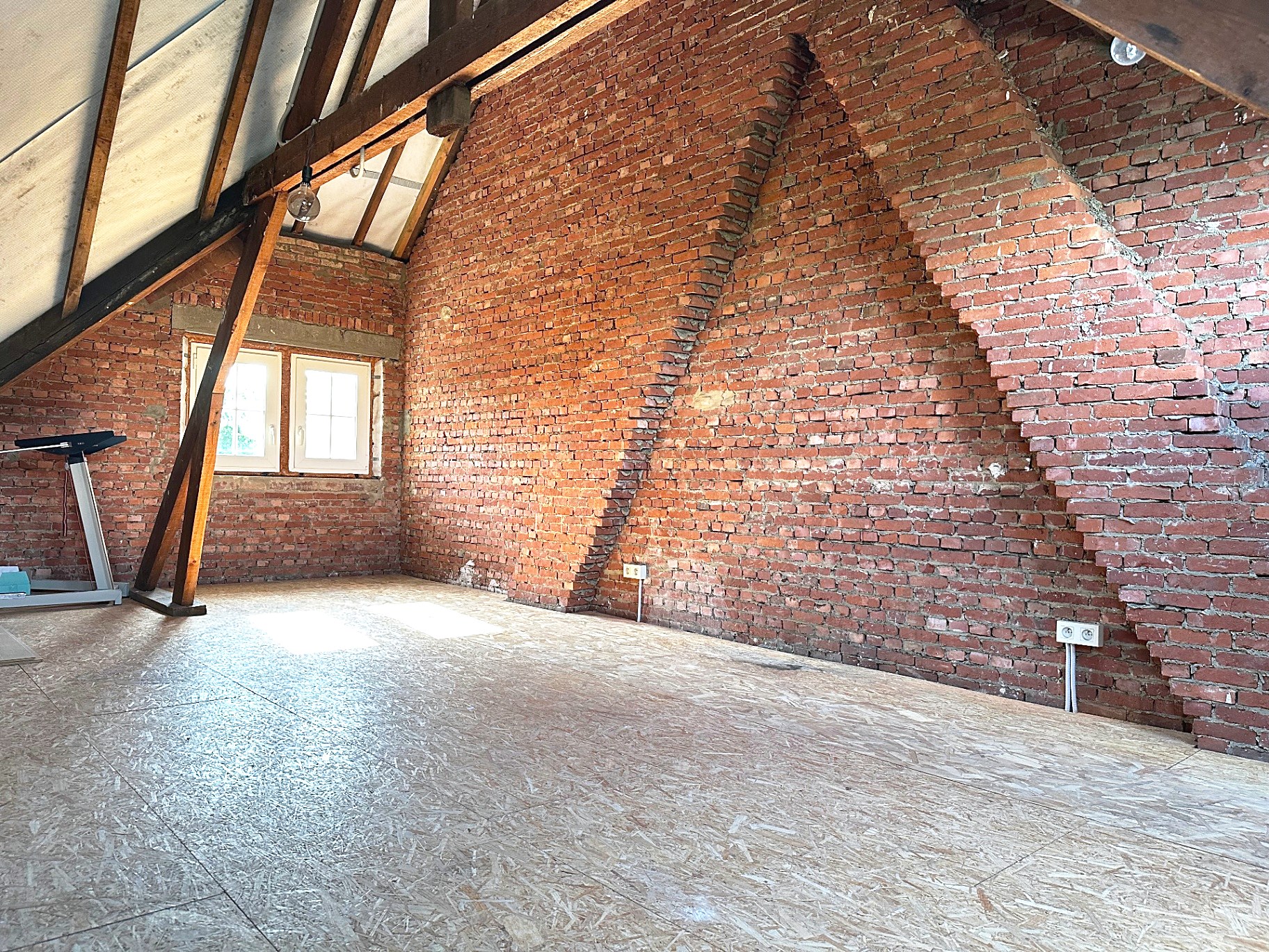 Zolder met authentieke bakstenen muur